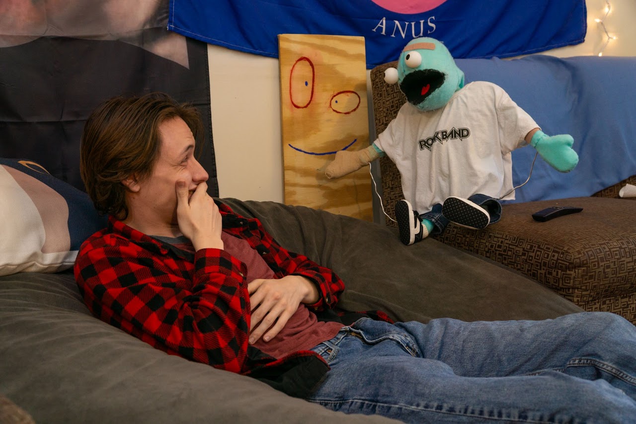 Chet is regailing his friend of his adventure, as they both laugh together.